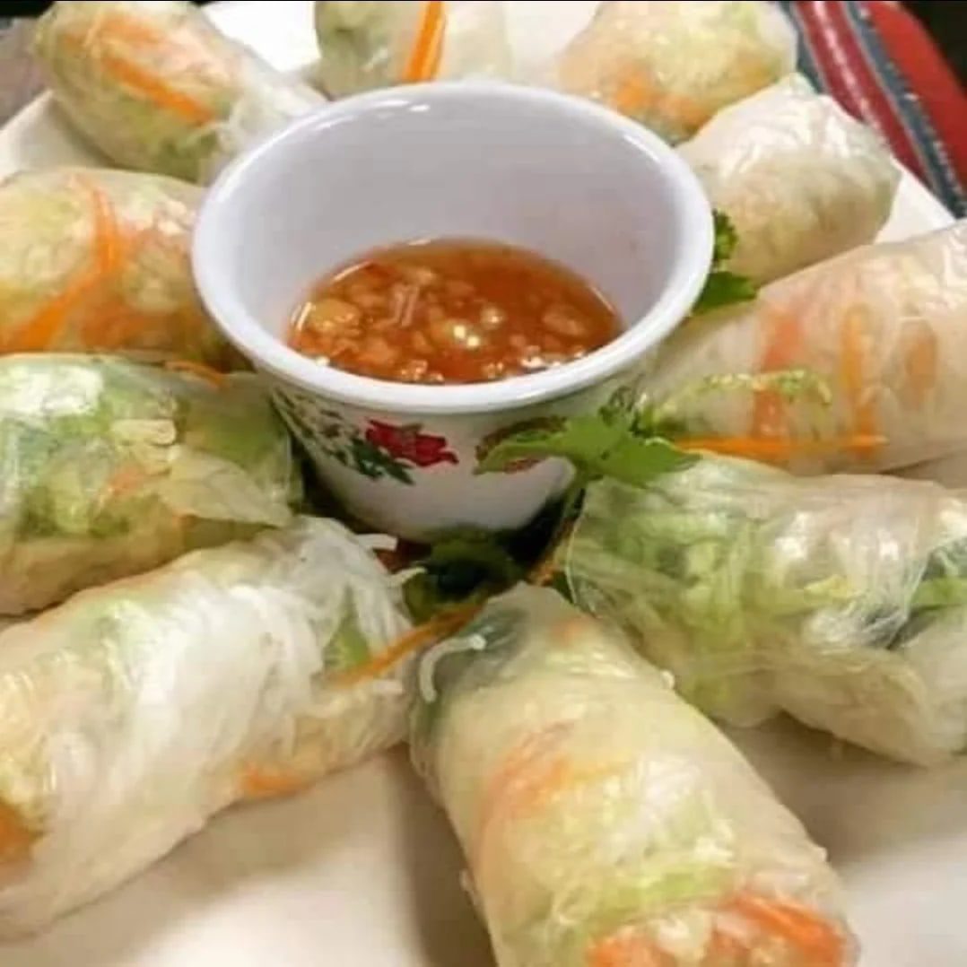 Fresh spring rolls with dipping sauce on a plate.