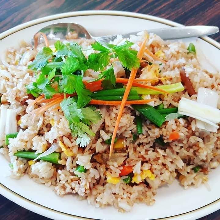 Plate of fried rice with vegetables and cilantro garnish.